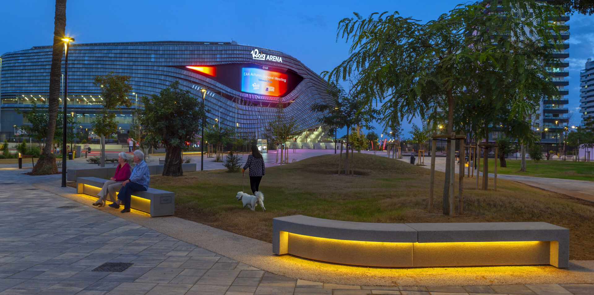Espacio urbano de estadio Roig Arena con bancas de hormigón iluminadas